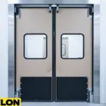 Tan double-swing warehouse impact door with large vision panels and kick protection in a production facility Tan double-swing warehouse impact door with large vision panels and kick protection in a production facility