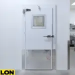 White insulated cooler door with diamond plate kick plate and small vision window in a commercial kitchen environment