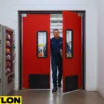Worker exiting through red PE-Series Factory Break Room Doors separating production and staff areas