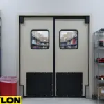 Beige industrial impact doors with kick plates in supply storage area