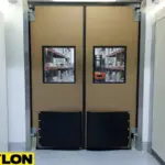 Brown industrial impact doors with reinforced panels in factory hallway