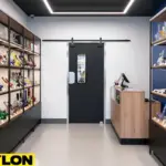 “Single black retail swinging door in smoke shop back-room entrance, with display shelves on both sides.”