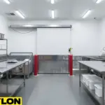 Commercial prep room with a sliding insulated cooler door, built to reduce air exchange and support consistent temperature conditions during busy operations.