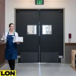 Commercial swinging doors in a winery service corridor shown with staff moving supplies through the entryway.