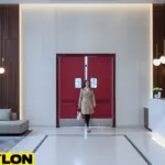 Guest walking through swinging doors near a hotel reception desk