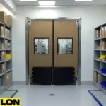 Industrial swinging doors in a compact manufacturing storage area designed to keep traffic moving smoothly through tight spaces.