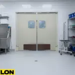 Light-colored double swinging doors with kick plates in a wash and grooming area of an animal facility.