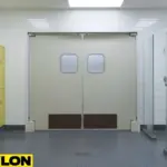 Light tan swinging doors with protective panels installed in a bright locker room with yellow lockers and tiled floors.