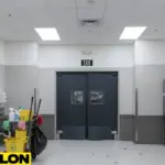 Maintenance corridor with swinging doors separating janitor closet and service areas