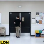 Person entering through black PE-Series swinging doors in a church multipurpose room.