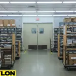 Postal sorting room with beige swinging doors that allow staff to move carts and parcels easily between busy back-room areas.