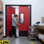 Red PE-series swinging doors designed for packaging rooms with frequent cart movement.