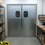 Silver PE-series commercial swinging doors in a packaging room with shelving and a packing workstation.