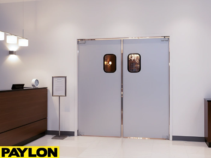 Swinging doors installed near a hotel front desk to control lobby traffic