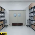 Double swinging doors in a staff supply area with shelving and clean back-of-house layout