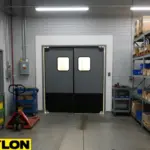 Industrial swinging doors supporting equipment movement in a maintenance shop