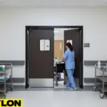 Nursing home staff moving cleaning cart through swinging doors without stopping workflow