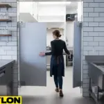 Staff member opening gray swinging doors in a bar prep area, demonstrating two-way traffic flow and efficiency.