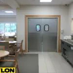 Swinging doors separating a nursing home dining area to support safe meal service flow