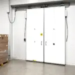 Air tight swinging door system installed on a commercial cooler in an industrial or food service facility.
