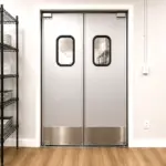 A commercial swinging traffic door installed in a restaurant kitchen or service area doorway.