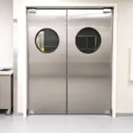 Easy access swinging doors installed in a busy commercial or industrial workspace, allowing smooth two-way passage.