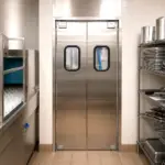 A heavy duty swinging traffic door suited for high-use kitchen and restaurant doorways.