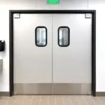 Low maintenance swinging doors installed in a commercial facility, suitable for high-traffic interior doorways.