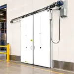 PAYLON PC-2000 energy saving swinging door installed at a commercial cooler entrance in a refrigerated storage area.