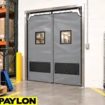 Heavy-duty PVC swinging doors installed in a high-traffic industrial or commercial facility doorway.