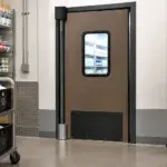Insulated swinging door installed at a grocery store dairy cooler entrance, keeping cold air contained in the refrigerated zone.